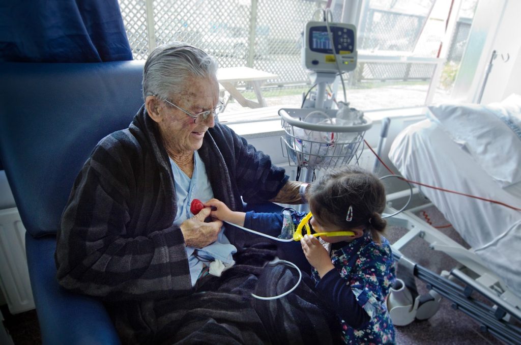 Old man in nursing home with granddaughter