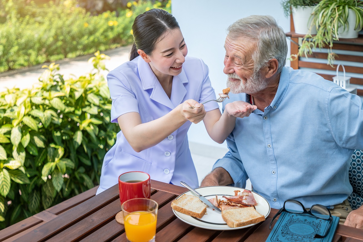 Aide feeding man